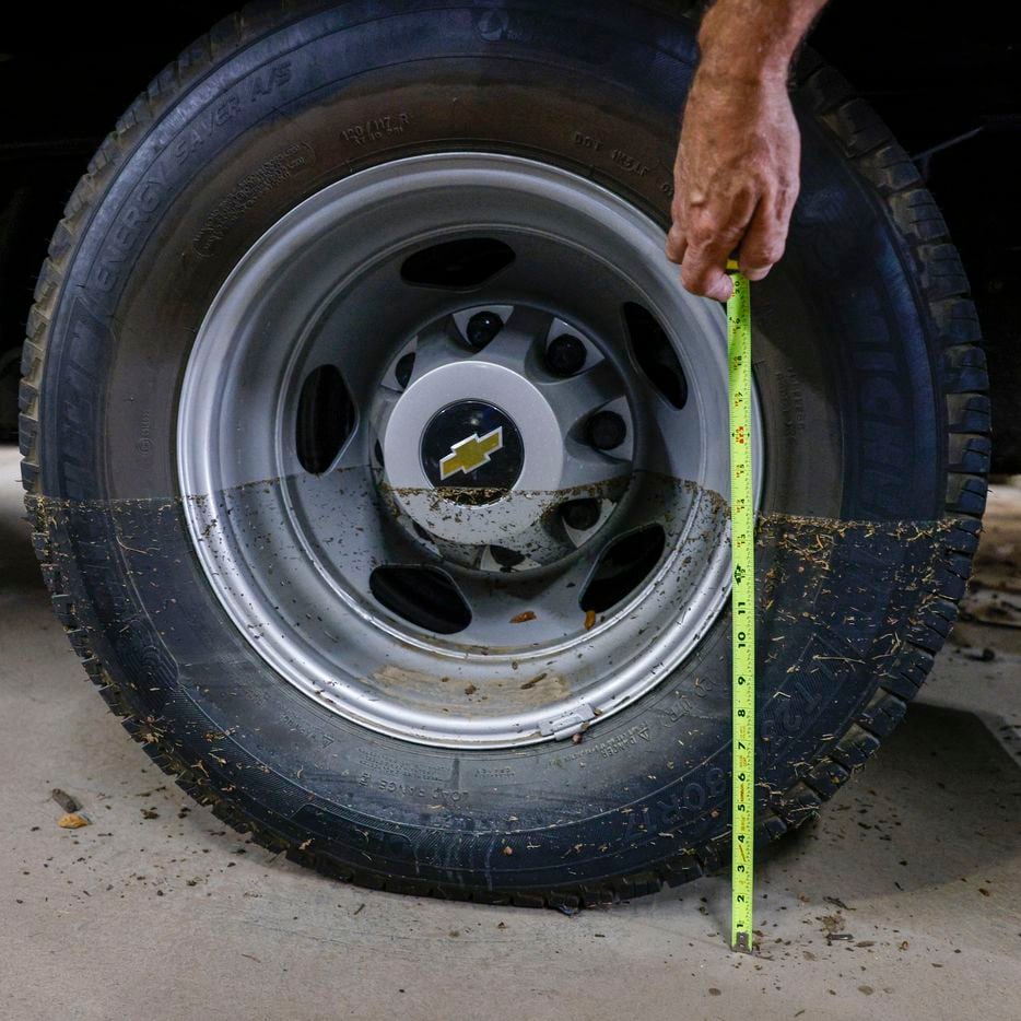 Truck driver Carter Mattingly measures the water line on a truck tire at McMurray Metals a...