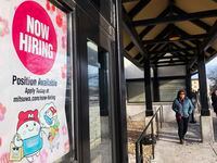 File - A hiring sign is displayed at a grocery store in Arlington Heights, Ill., Tuesday,...
