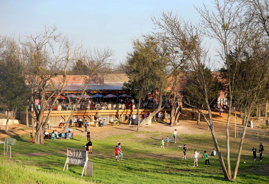 Kids play in the open field in front of the patio at The Stix Icehouse in McKinney.