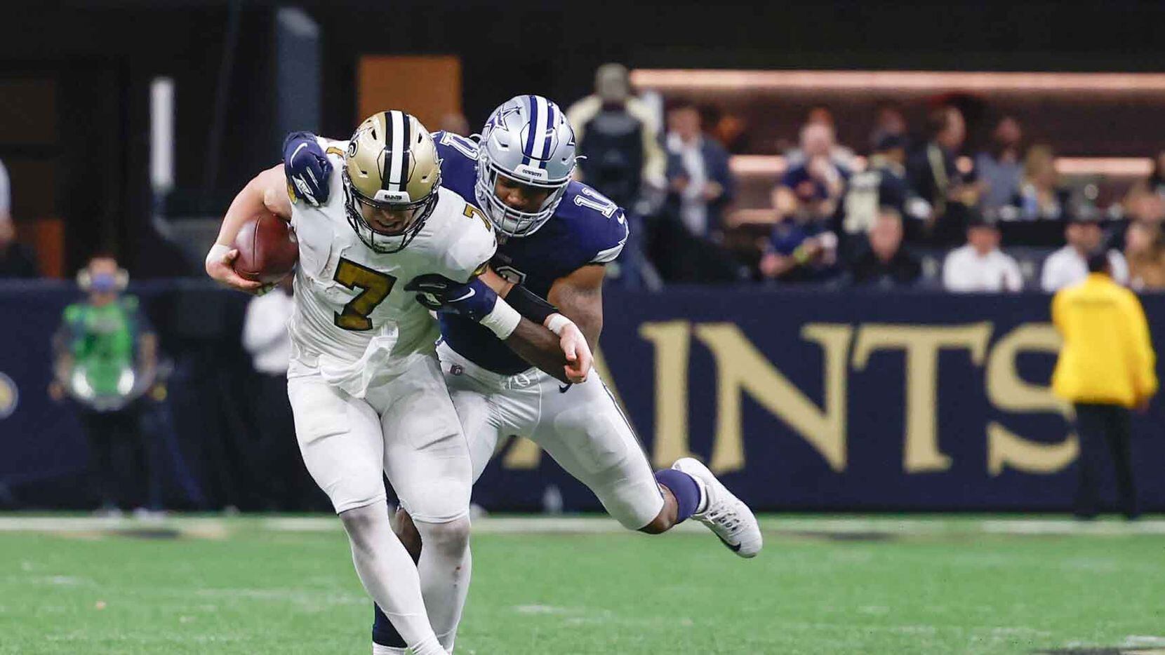 New Orleans Saints quaterback Taysom Hill (7) gets tackled by Dallas Cowboys linebacker Micah Parsons (11) during the second half at the Caesars Superdome in New Orleans, Louisiana December 2, 2021.