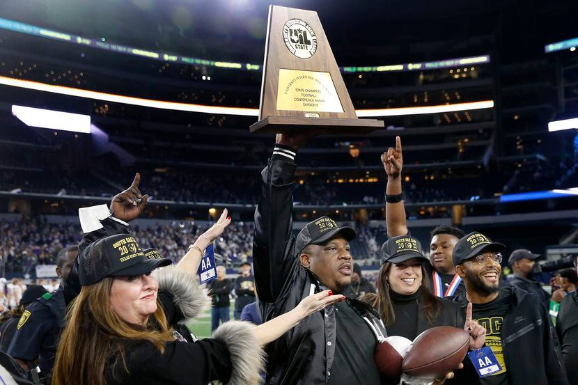 South Oak Cliff coach Jason Todd hoists the Class 5A Division II state championship trophy...