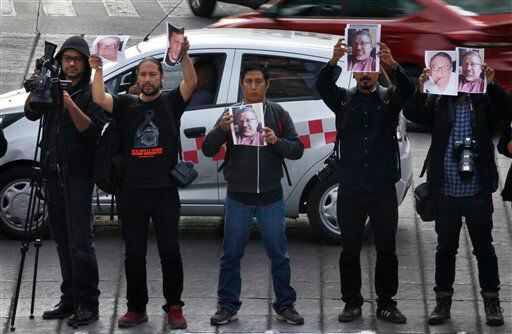Periodistas sostienen fotos de su colega asesinado, Javier Valdez, durante una protesta...