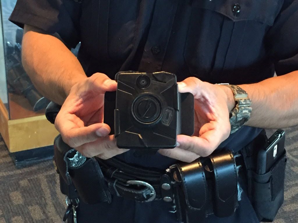 A Dallas police officer holds a Taser Axon Flex body camera at Jack Evans Police...
