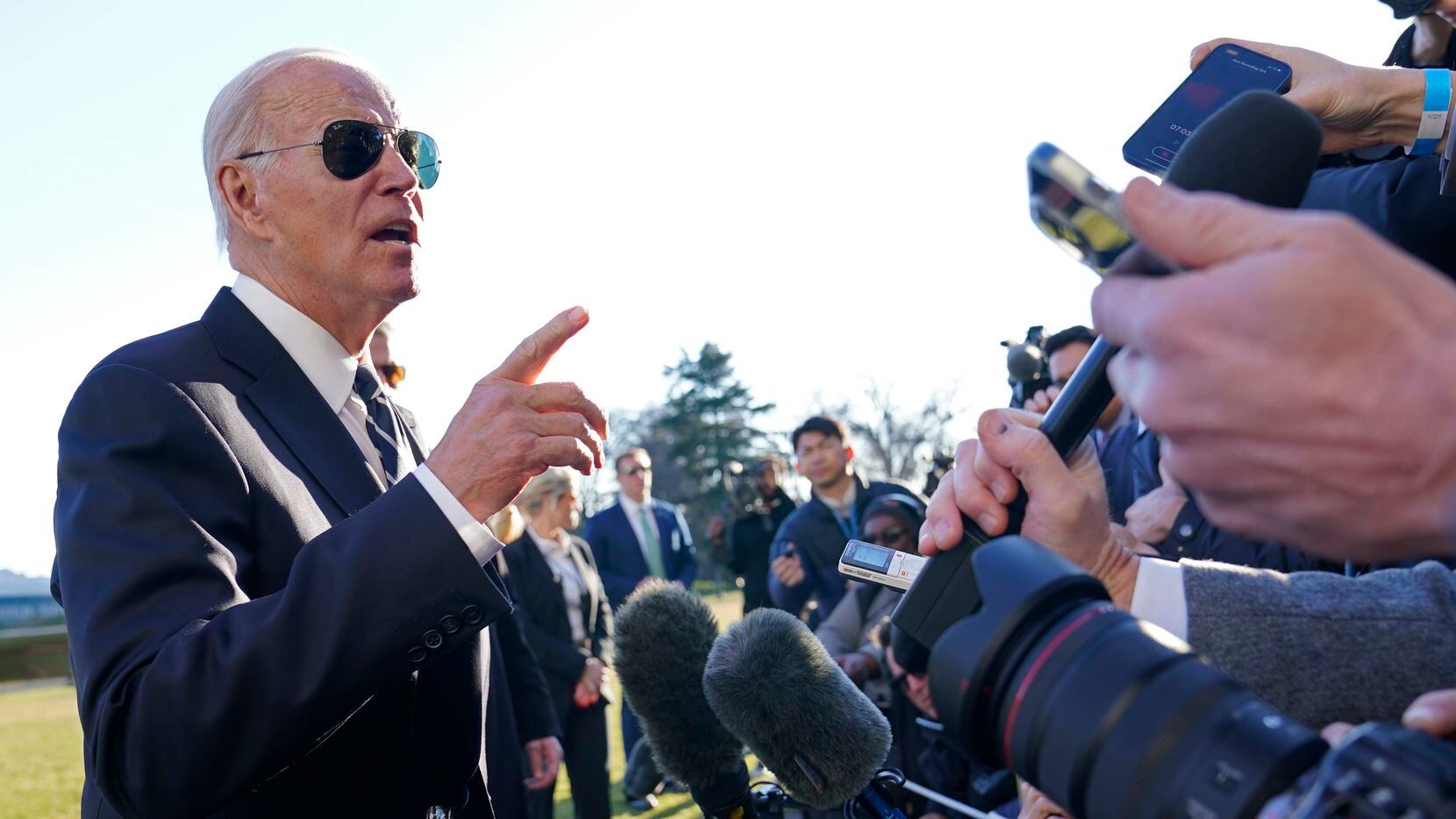 President Joe Biden talks with reporters on the South Lawn of the White House in Washington,...