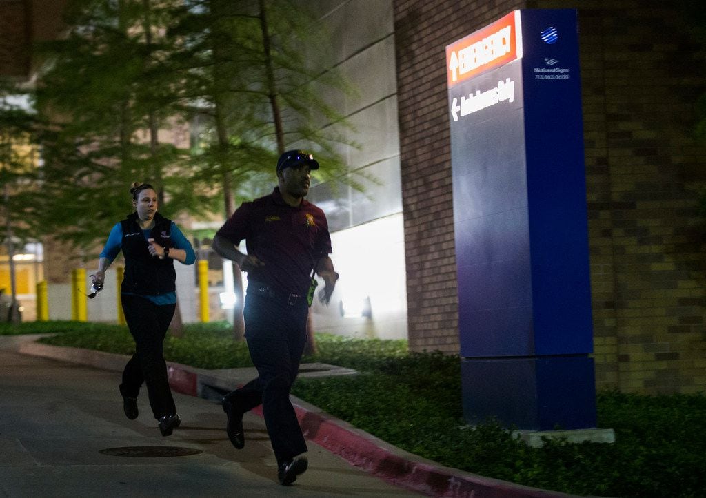 Police officers run away from the emergency room to their cars at Texas Health Presbyterian Hospital Dallas after a man shot two officers outside a Home Depot on Tuesday, April 24, 2018 in Dallas. (Ashley Landis/Staff Photographer)