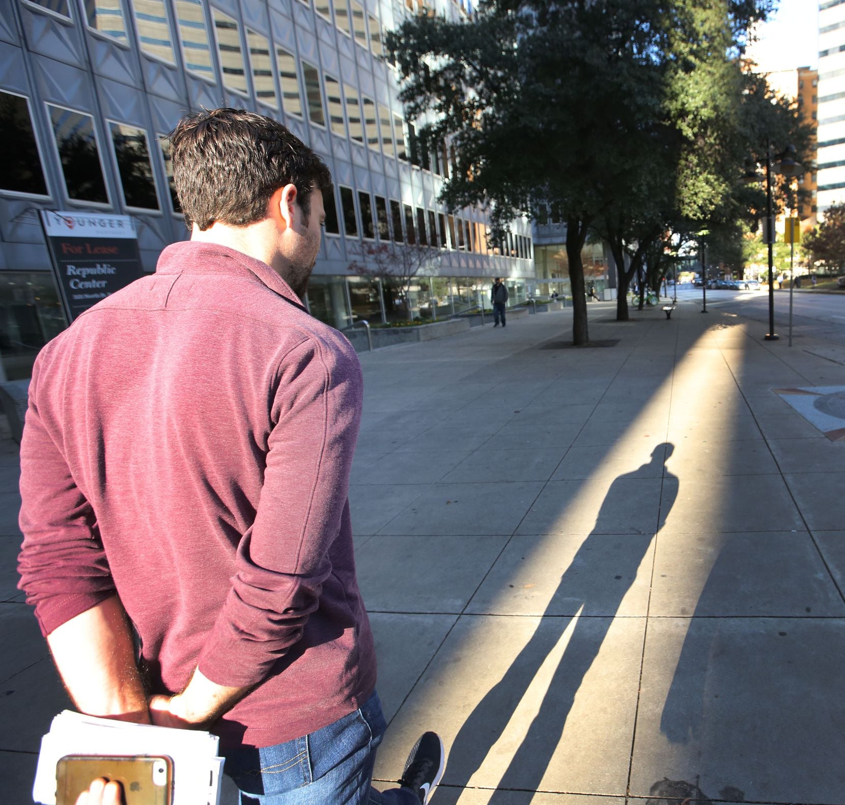 Dallas Morning News reporter Brendan Meyer walks from the office on Commerce Street to St....