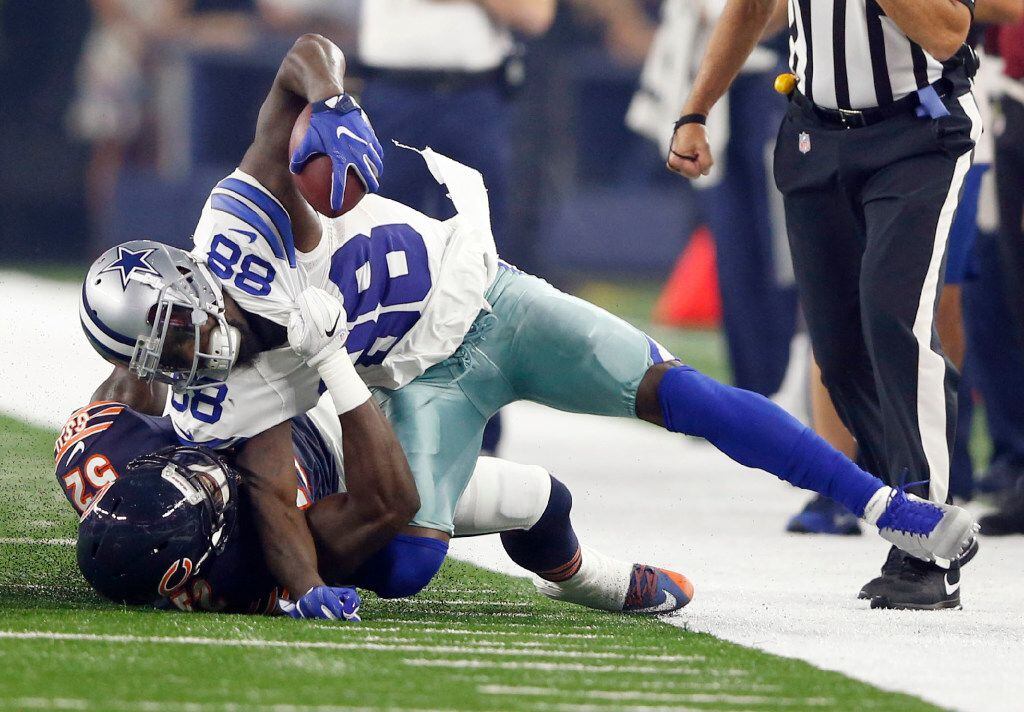 Dallas Cowboys wide receiver Dez Bryant (88) gets pulled down with his foot caught...