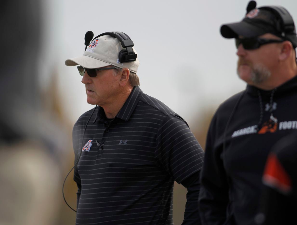 Aledo head football coach Tim Buchanan, left, watches game action from the team bench area...