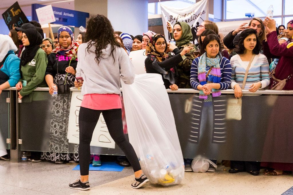 Protestors gather trash at DFW International Airport where they gathered in opposition to...