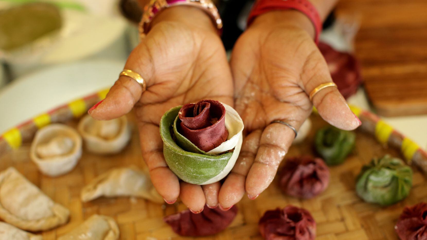 Minu Amatya with Momo Shack Dumplings holds a Nepali dumpling shaped like a rose.