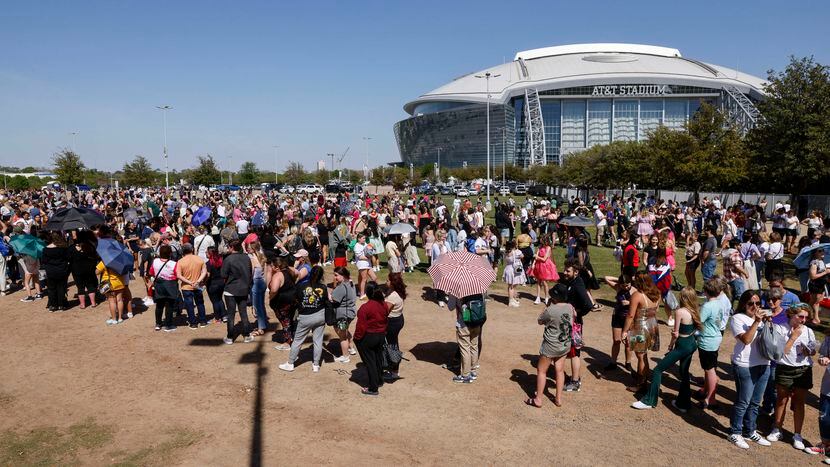 Fans wait in line to buy merchandise before a Taylor Swift Eras Tour concert at AT&T Stadium...