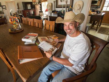 Mike Newton, known as the Cowboy Chef, studies cookbooks at the table where he and his wife...