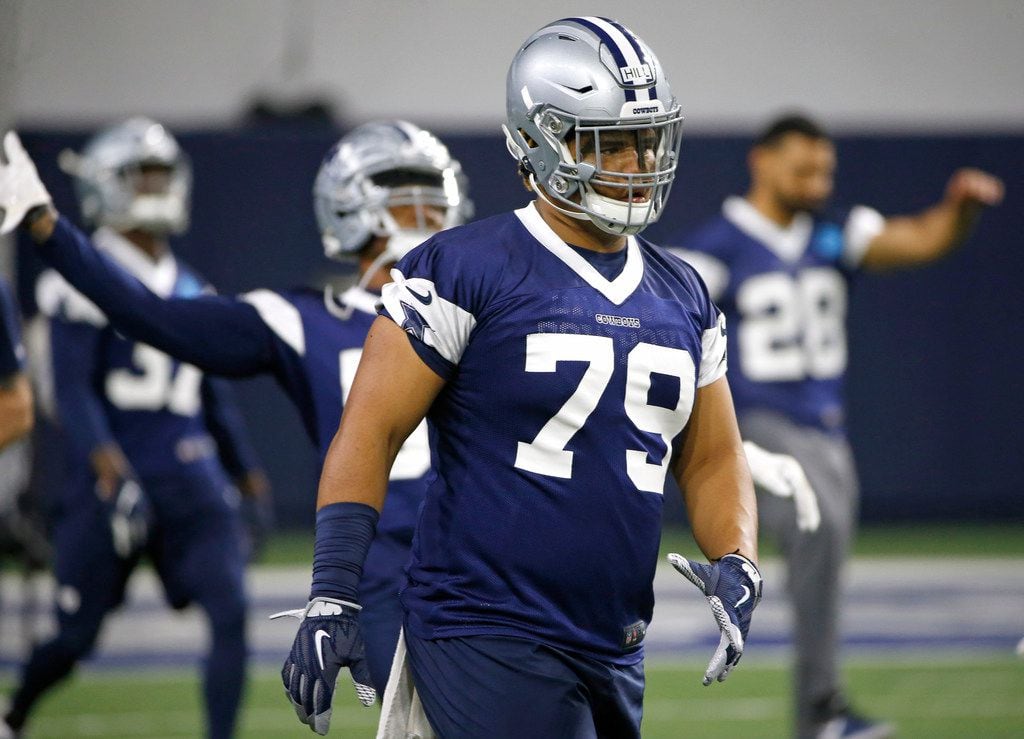 Dallas Cowboys defensive tackle Trysten Hill (79) warms up with teammates during an...