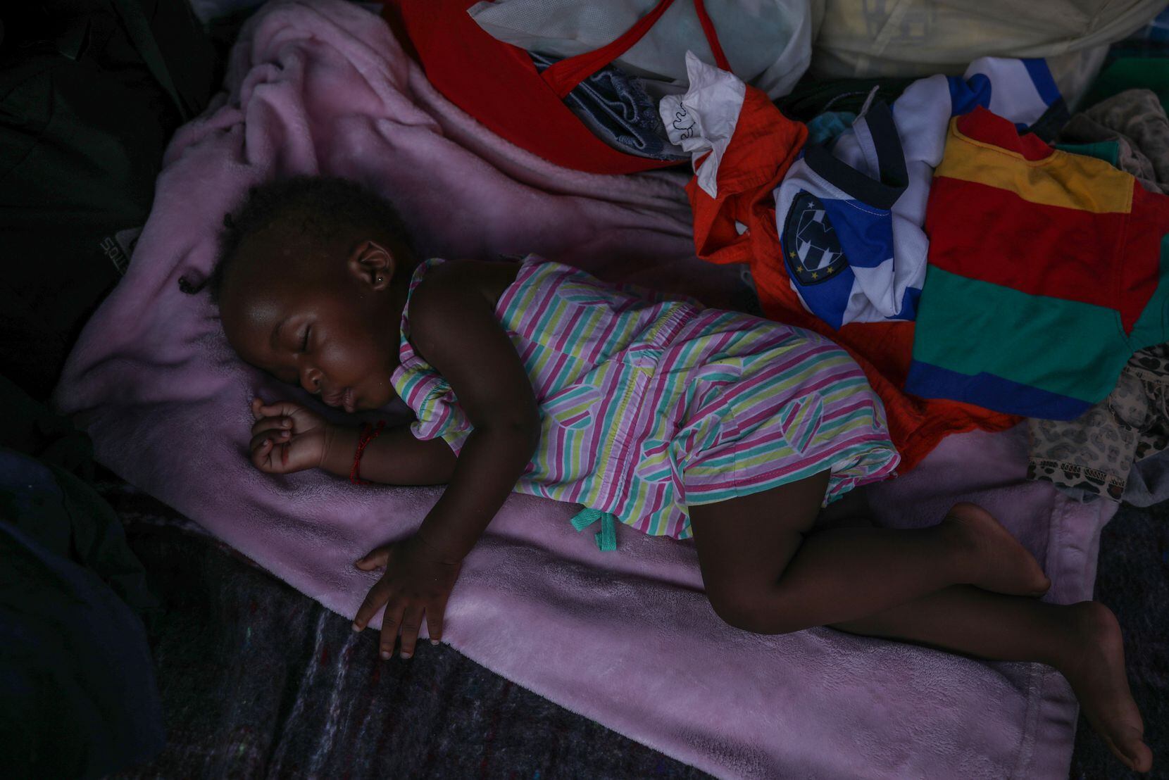 An 11-month-old baby sleeps outside Casa Indi, which serves as a dining room and shelter for...