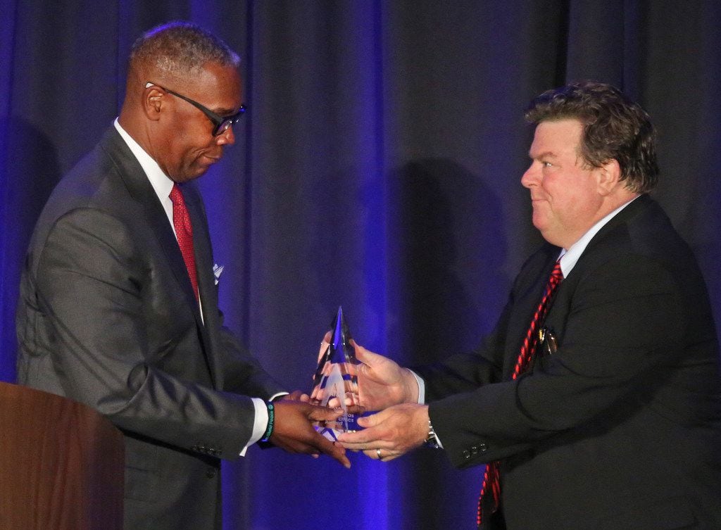 AT&T Chief Compliance Officer David Huntley, left,  accepts an ethics award from Michael...
