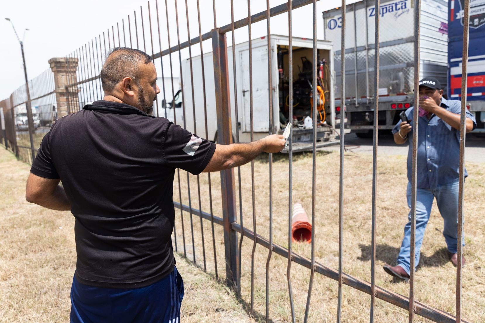 Alfredro Castro (left), a traffic manager with a Mexican trucking firm, handed one of his...