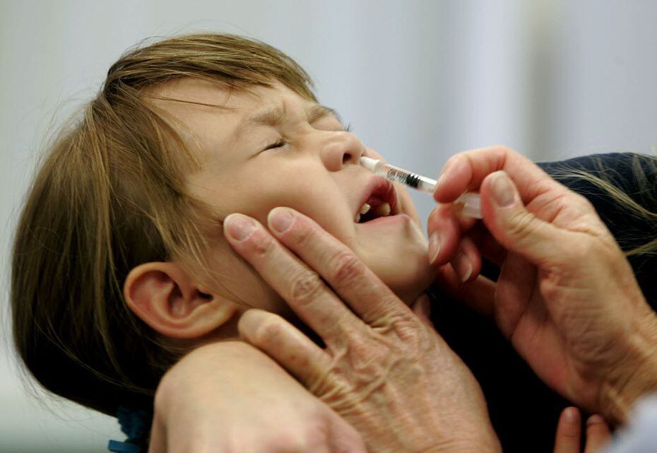 Danielle Holland reacts as she is given a FluMist influenza vaccination in St. Leonard, Md....