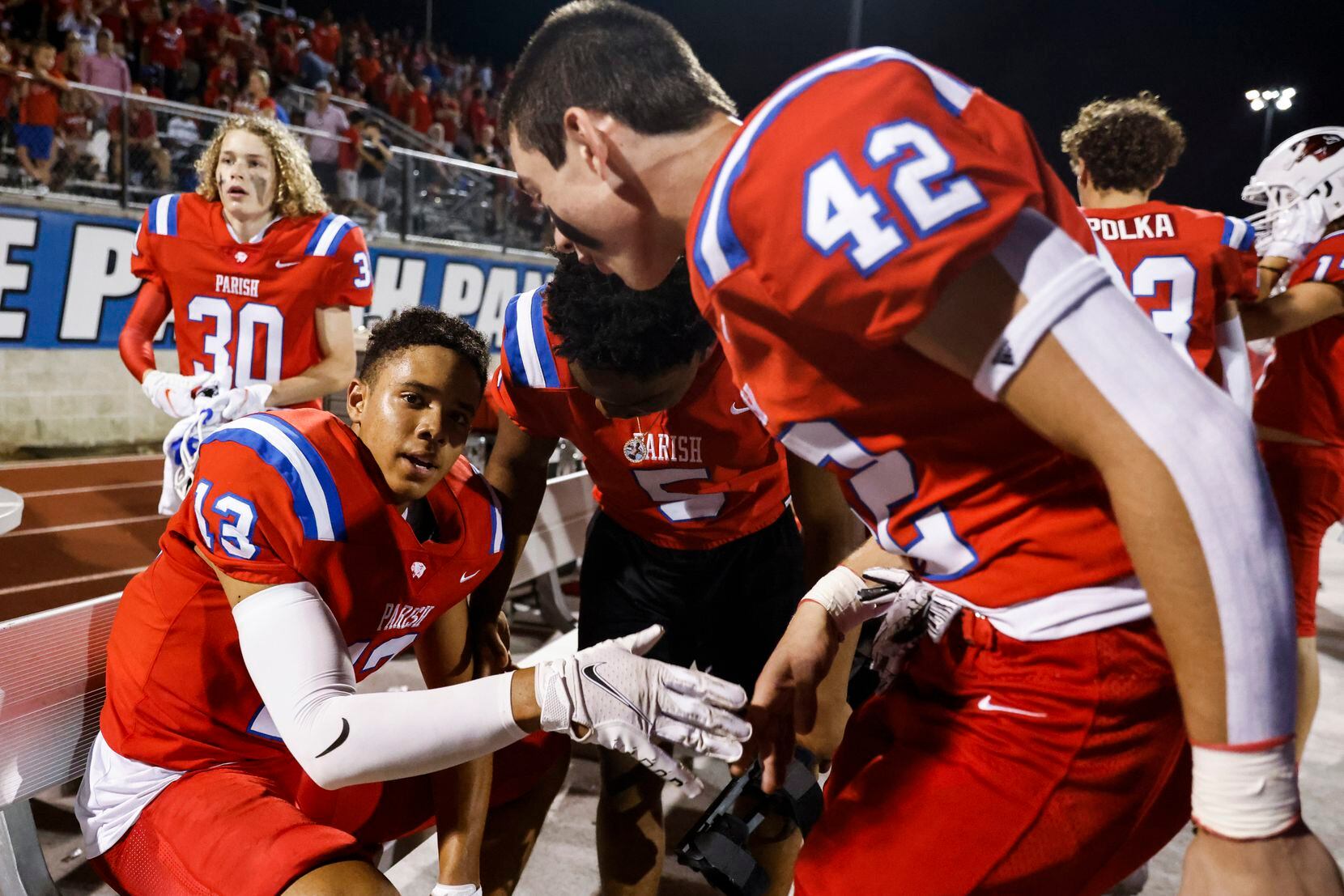 Parish Episcopal’s Bryson Fields (13) looks as he gets cheered by his teammates after...