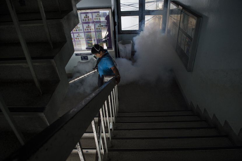 Un trabajador de la ciudad fumiga los pasillos de una escuela en Bangkok, en septiembre de...