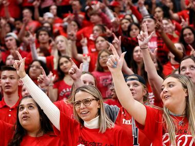 The Texas Tech Red Raiders student body get their ‘guns up’ hand sign before their team...