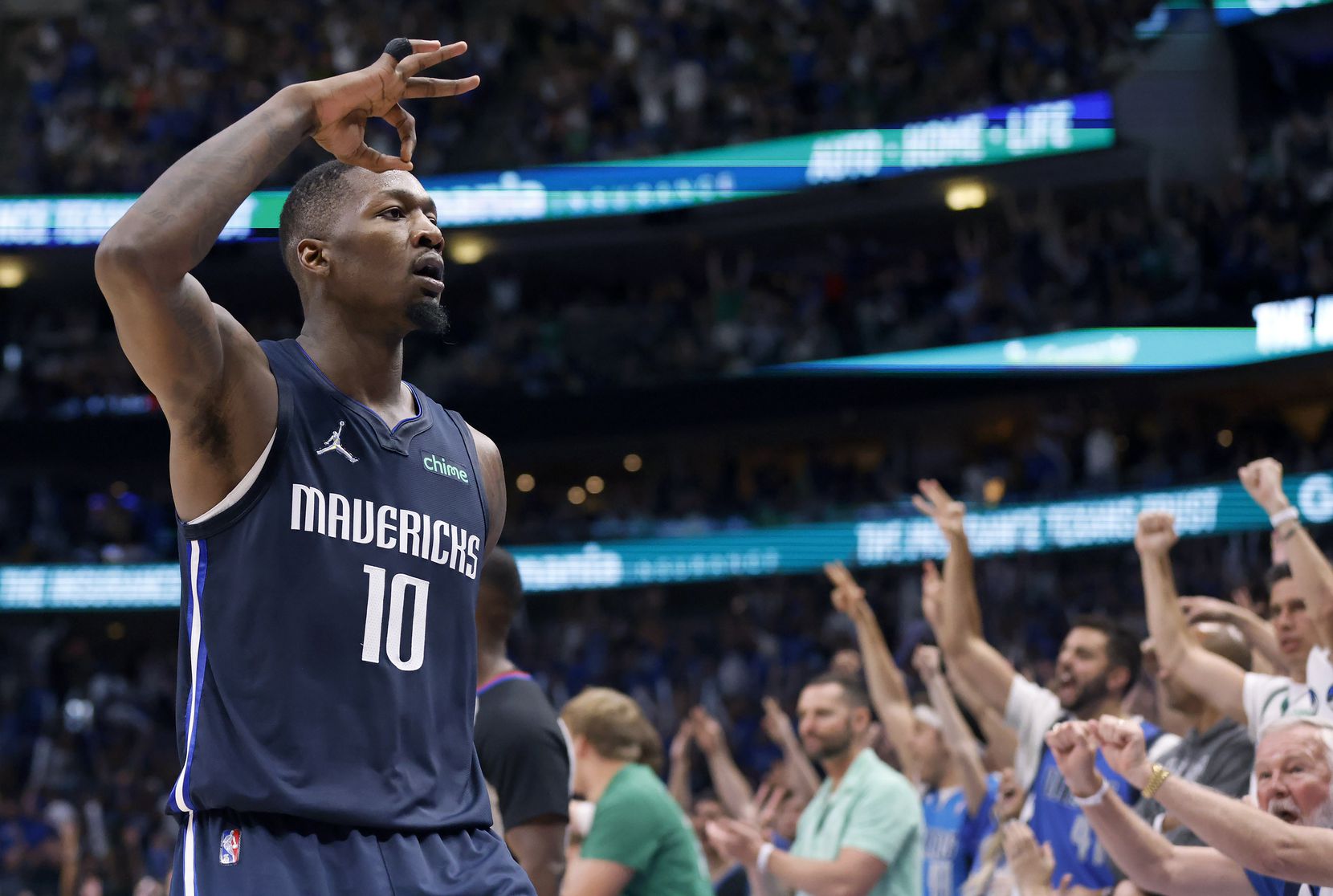 Dallas Mavericks forward Dorian Finney-Smith (10) reacts to cheering fans after a second...