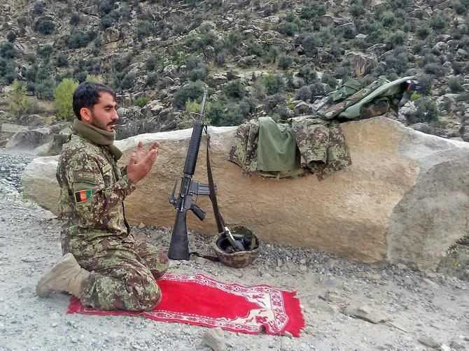 
An Afghan army soldier prayed while fighting Taliban insurgents last week in the rugged...