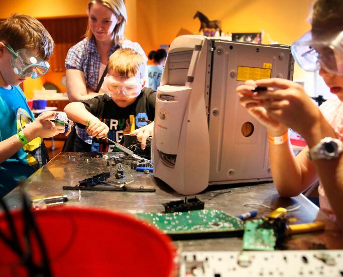 Children deconstruct a computer at the Fort Worth Museum of Science and History's Take...