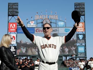 FILE - San Francisco Giants manager Bruce Bochy gestures toward fans next to his wife Kim...