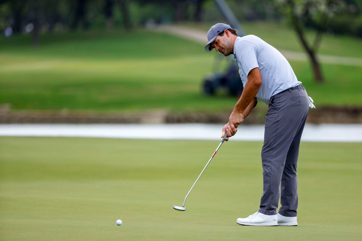 Former Dallas Cowboys quarterback Tony Romo putts the ball on the 18th green during the...