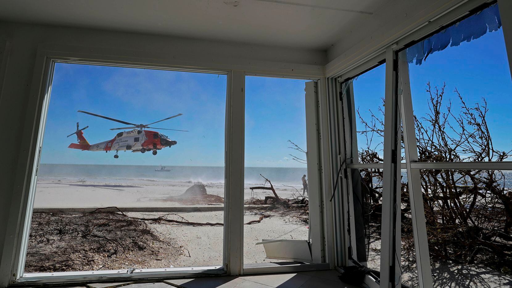 Un helicóptero de la Guardia Costera de Estados Unidos visto desde el interiro de una casa...