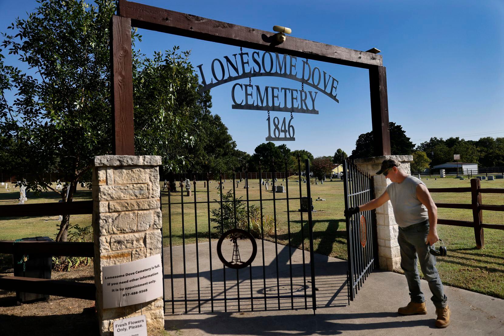 Maintenance man Joe Beatty closes the gate to the historic Lonesome Dove Baptist Cemetery...