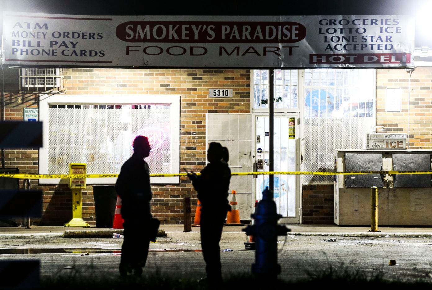 Fort Worth police officers investigate the scene of a shooting at Smokey's Paradise Food...