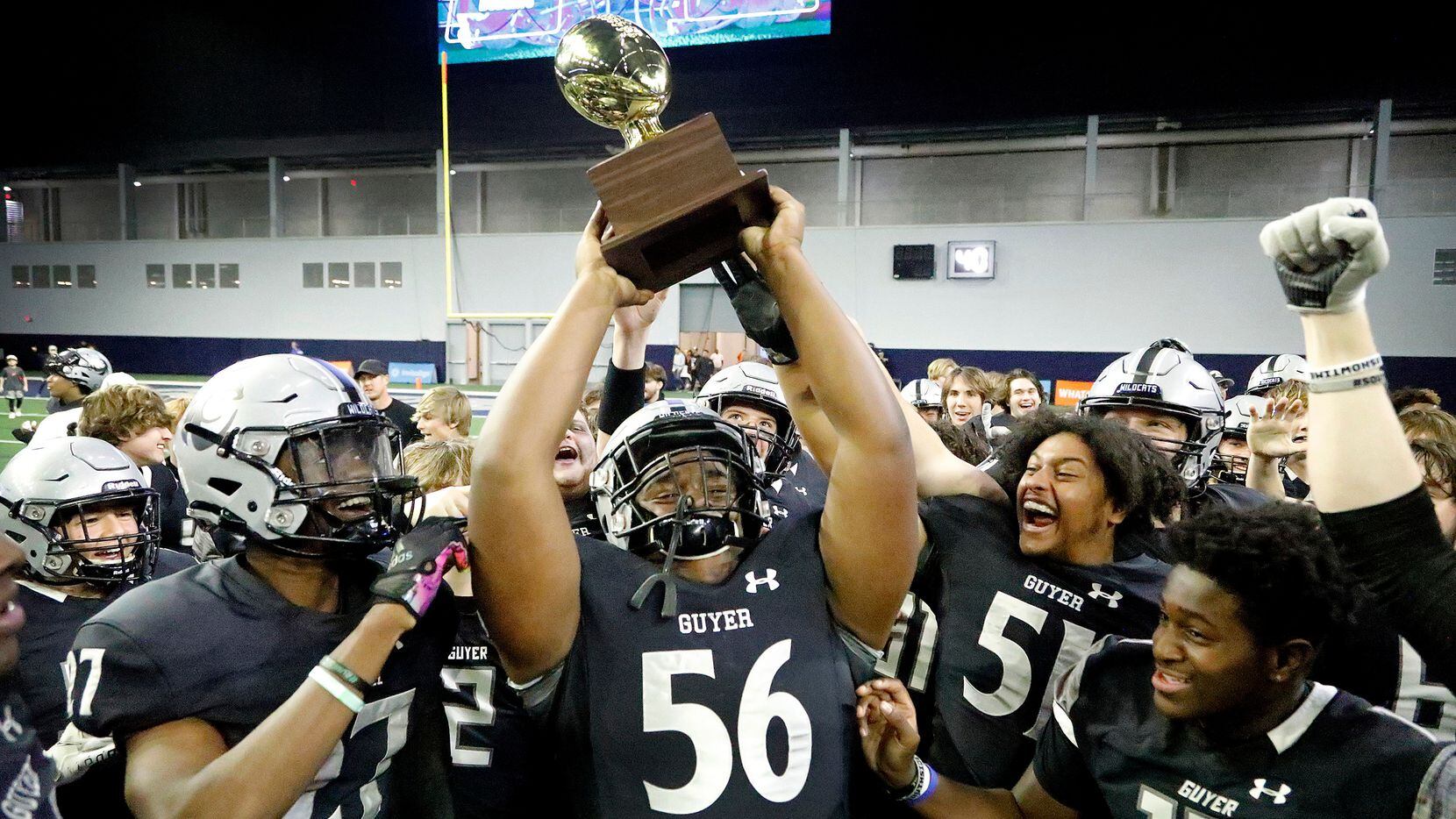 Guyer High School defensive lineman Dynell Neal (56) hoists up the trophy after the win as...