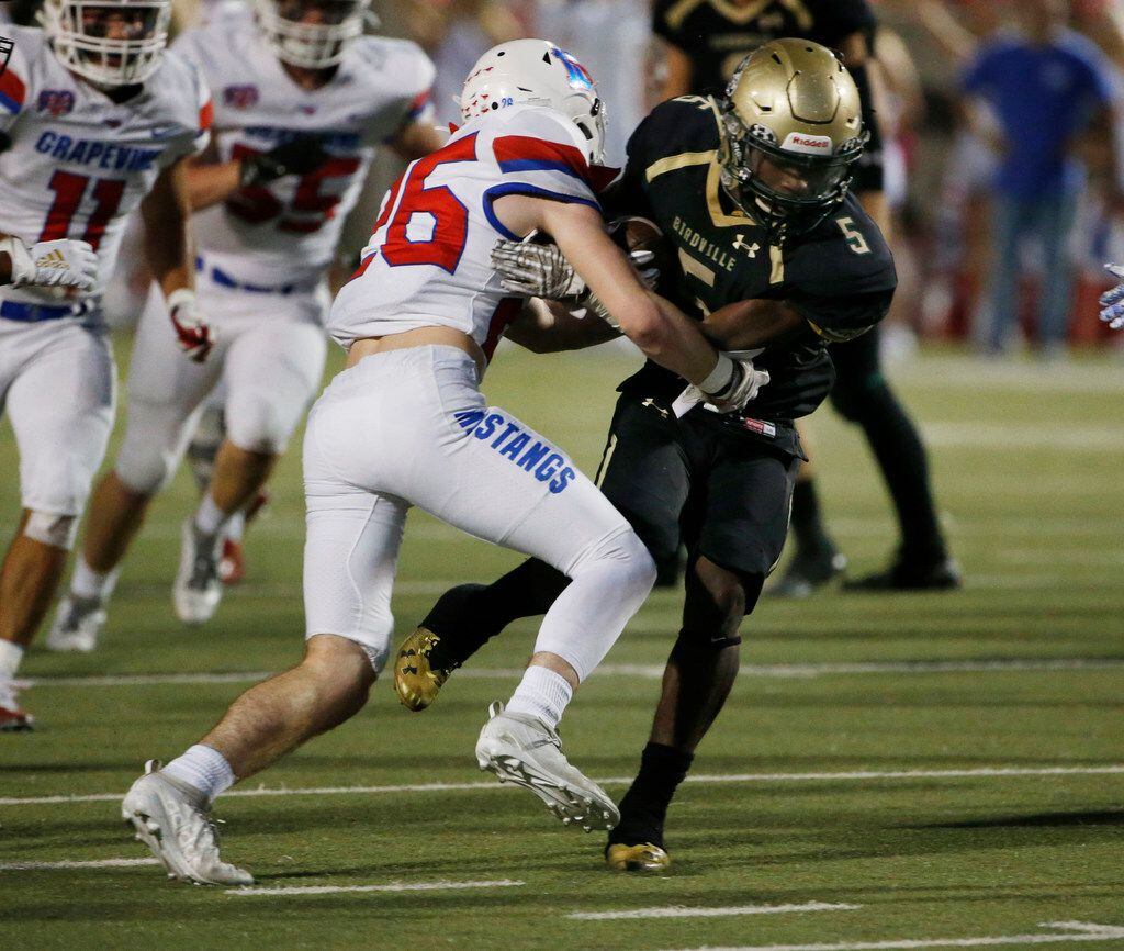 Grapevine's Keegan Courtney (26) tackles Birdville's Demarye Walker (5) during the first...