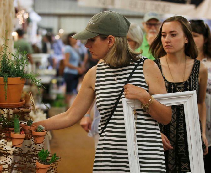 Shoppers look at goods in an indoor vendors' market.