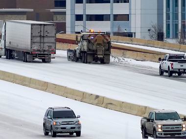 A truck spreads sand on US-75 near Renner Road on Tuesday, Jan. 31, 2023, in Richardson. ...