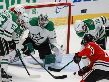 The puck rebounds from Dallas Stars goaltender Jake Oettinger (29) moments before Chicago...