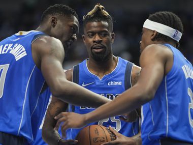 Dallas Mavericks forward Reggie Bullock (25) huddles with forward Dorian Finney-Smith (10) and guard Frank Ntilikina (21) during the first half of an NBA basketball game against the Sacramento Kings at American Airlines Center on Sunday, Oct. 31, 2021, in Dallas.