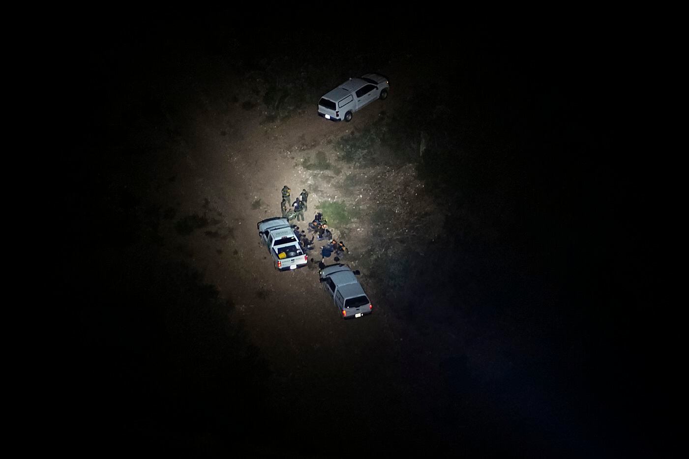 A group migrants is seen illuminated by the search light from a Texas Department of Public...