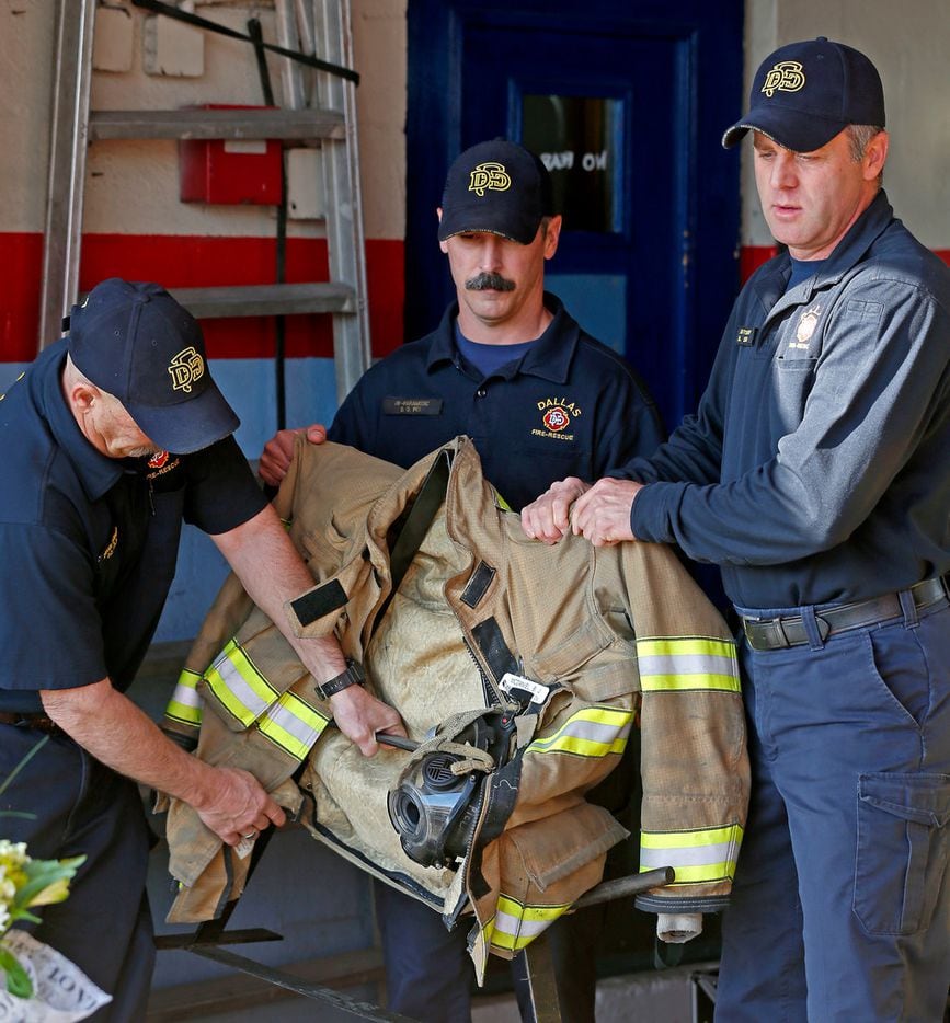 Lt. Ray Smith (right) and firefighters Devin Holt (left) and Daniel Fox carry Brian McDaniel's gear during a news conference at Fire Station 36 in Dallas on March 13, 2018. McDaniel died in a helicopter crash on Sunday in New York.