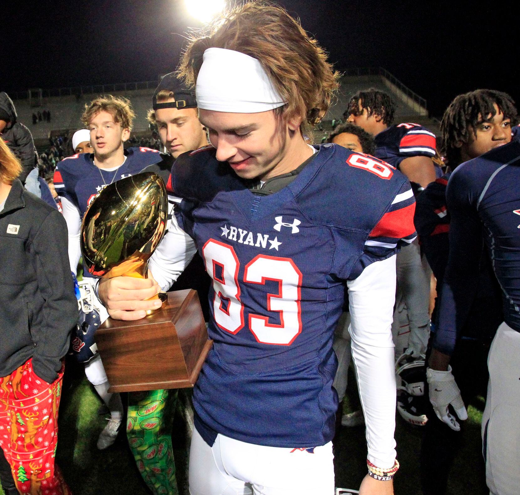 Denton Ryan K Clayton Roblyer (83) admires the game trophy, after the Ryan coach handed it...