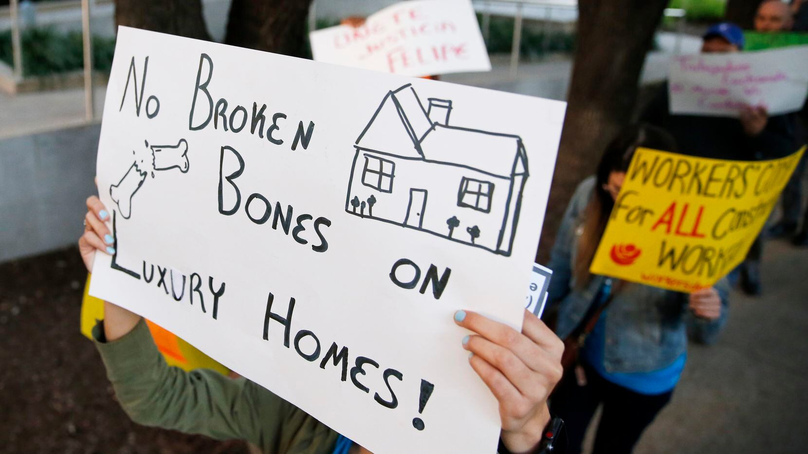 Protesters carried signs outside First Texas Homes' office in Uptown Dallas on Feb. 24,...