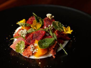 Roasted beets with Skyr yogurt, bitter greens and local honey is garnished with edible flowers.