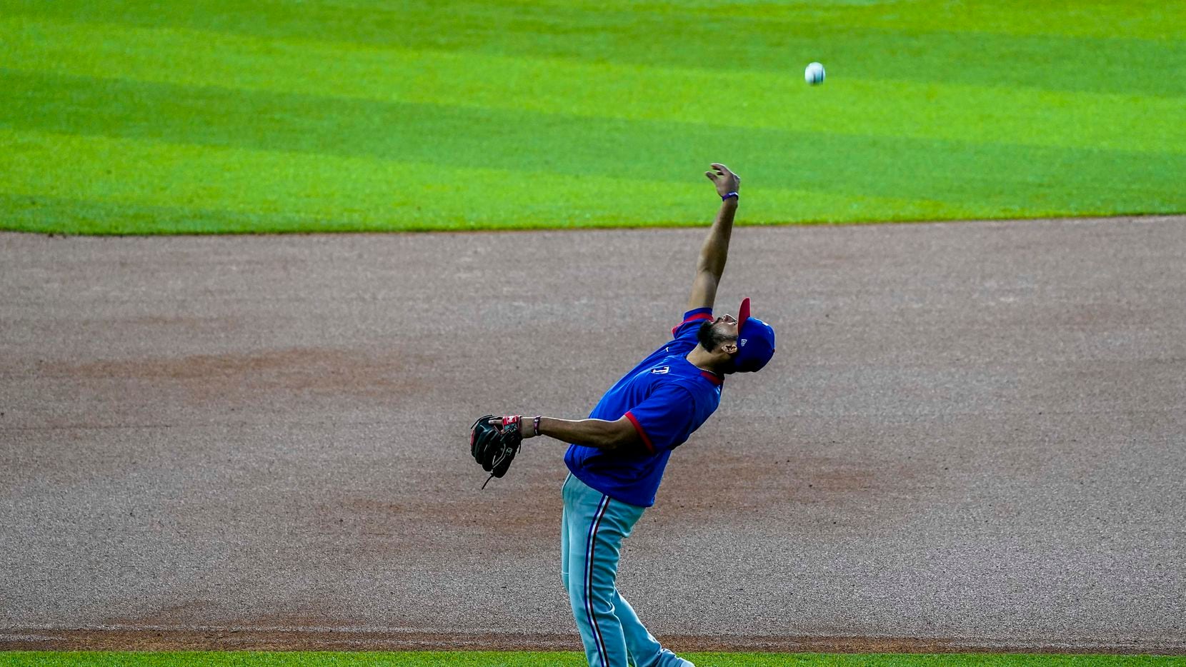 Texas Rangers infielder Isiah Kiner-Falefa tosses a ball in the infield during the Rangers...
