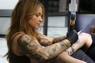 Deanna James, owner and resident artist of Eden Body Art Studios, tattoos a client. Eden...