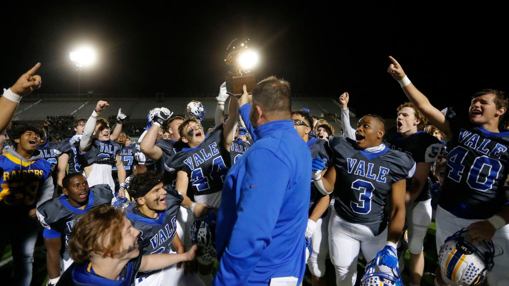 Sunnyvale players celebrate, as head football coach John Settle holds up a game trophy at...