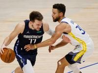 Dallas Mavericks guard Luka Doncic (77) drives on Golden State Warriors guard Stephen Curry (30) during the fourth quarter of play at American Airlines Center on Saturday, February 6, 2021 in Dallas.