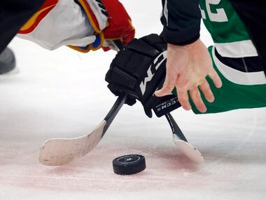 The referee drops the puck on a face off between the Dallas Stars and Calgary Flames during...