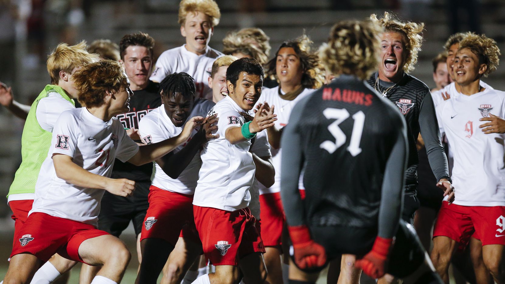 Rockwall-Heath senior defender Oscar Perales, center, is mobbed by teammates after scoring the game winning goal in a shootout after a boys soccer Class 6A state semifinal against Allen at Mesquite Memorial Stadium in Mesquite, Tuesday, April 13, 2021. Rockwall-Heath won 3-1 in a shootout.