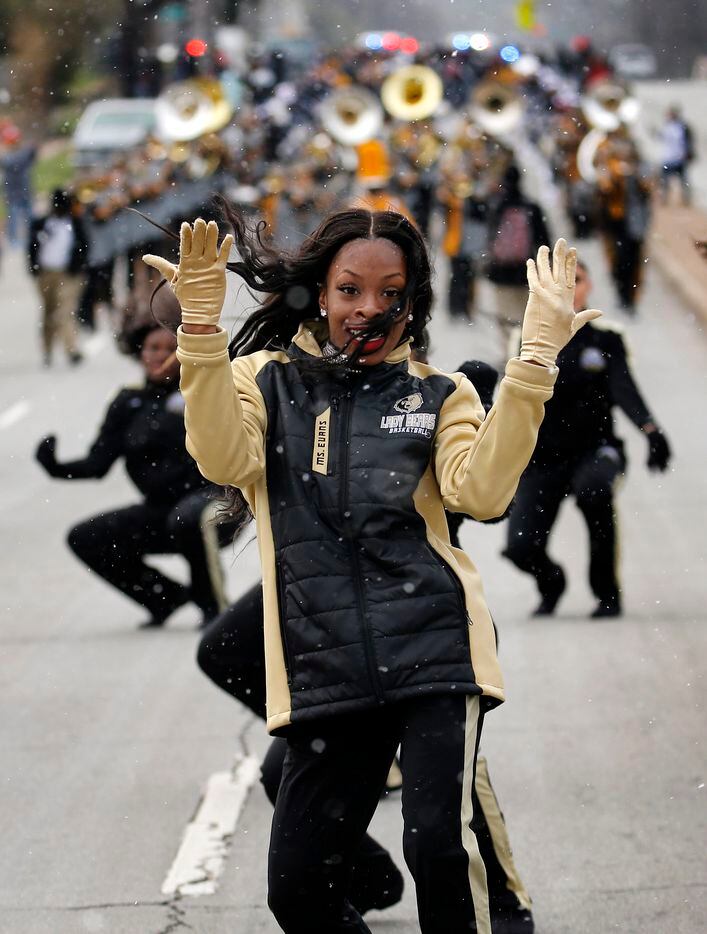 With falling snow, the SOC Pivoteers dance troupe marched down S. Marsalis Ave from nearby...